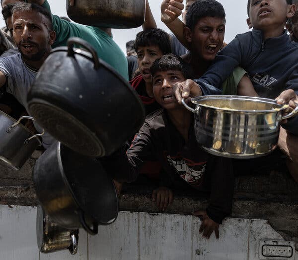 Children gather with cooking pots in Jabaliya, Gaza.
