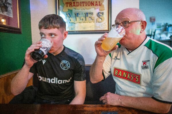 Mark Rogers and his son Ben, supporters of Walsall Football Club, savor beers from NoFo Brew Co, a Georgia-based microbrewery sponsoring the English team.
