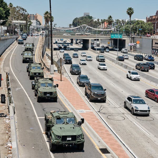 Military vehicles positioned on a downtown Los Angeles highway amid immigration demonstrations.