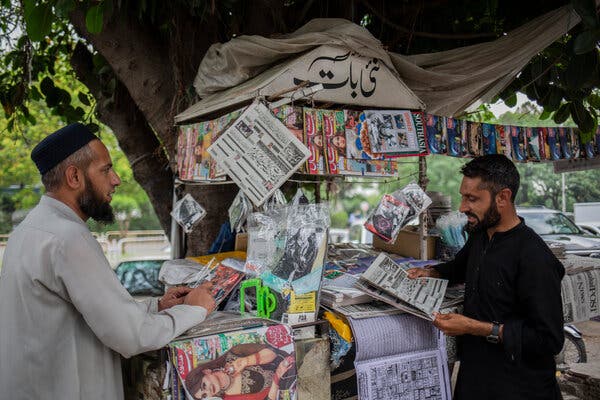 Zakir Khan reads a newspaper at a stand in Islamabad owned by Nazaman Abbasi. The headline highlights diplomatic efforts to ease tensions between India and Pakistan.