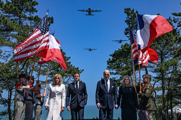 President Emmanuel Macron and President Joseph R. Biden Jr., with their spouses, at a Normandy D-Day remembrance ceremony last year.