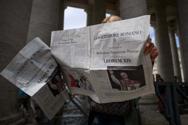 An individual reads the Vatican’s L’Osservatore Romano newspaper on Friday in Vatican City, showcasing the new pope.