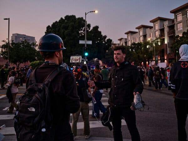 Cam Higby, a digital content creator, broadcasts live during immigration protests in downtown Los Angeles on Monday.