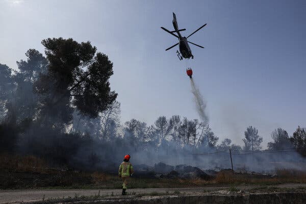 Water dropped from a helicopter to combat a forest fire in Latrun, central Israel, on Thursday.