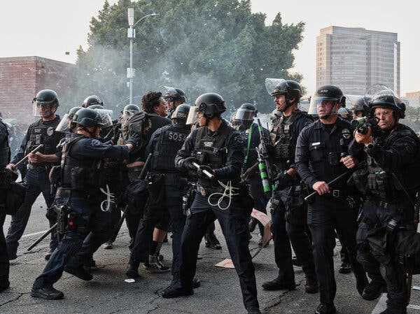 Law enforcement officers encircle a protester during demonstrations in Los Angeles on Monday.