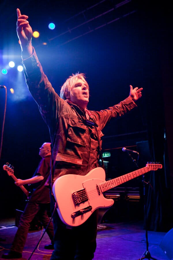 Mike Peters of The Alarm performing in London, 2009, showcasing the band’s energetic blend of punk and twin-acoustic guitars.