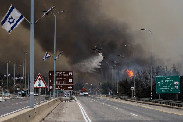 A helicopter combats a wildfire near Latrun, Israel, with water drops on Wednesday.