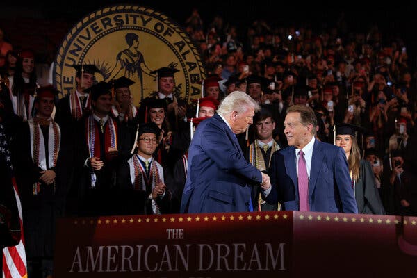 President Trump greets Nick Saban, former Alabama Crimson Tide football coach, before delivering a commencement address at the University of Alabama in Tuscaloosa.