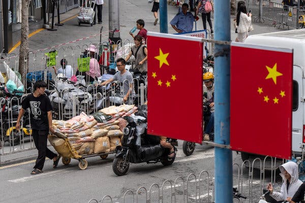 Workers move shipments through a garment wholesale and distribution area in Guangzhou, China, on Thursday.