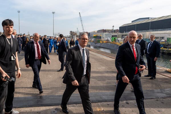 Prime Minister Keir Starmer walking beside a Royal Navy nuclear-powered submarine at a shipyard in Barrow-in-Furness, England, in March.